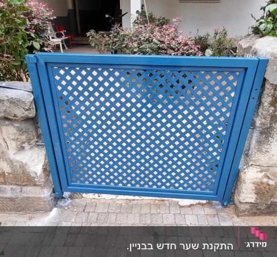 שער כחול עם דוגמת שתי וערב על שביל מרוצף